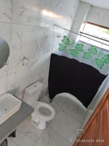 Un baño con inodoro y una sombrilla negra. en Dinart's House, en Lucena