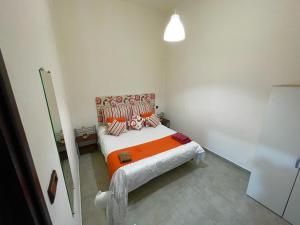 a small bedroom with a bed with an orange blanket at Anwal apart Fibra centro 6 personas excursions in Tetouan