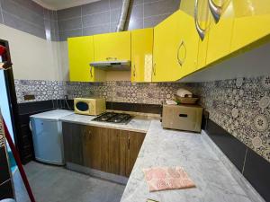 a small kitchen with yellow cabinets and a stove at Anwal apart Fibra centro 6 personas excursions in Tetouan