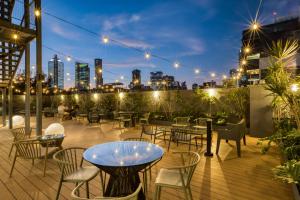 a patio with tables and chairs and a view of the city at ULIV Cibeles in Mexico City