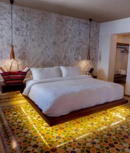 a bedroom with a large white bed with lights on it at Hotel Scappata in Progreso