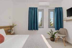 a bedroom with blue curtains and a bed and a chair at Areti Guesthouse in Víssani