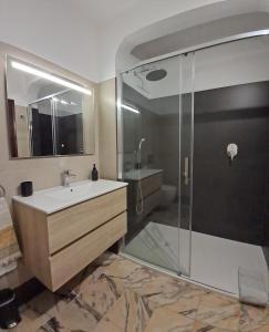 a bathroom with a sink and a glass shower at Apartamento Neptuno in Benagil