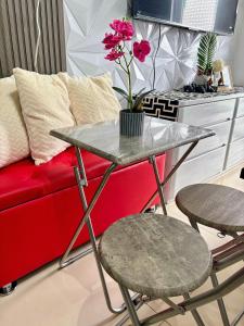 a table with two chairs and a red couch at Casa Manawari in Tagaytay