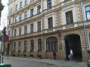 two people standing outside of a large building at Apartment in the Heart of Old Riga in Rīga