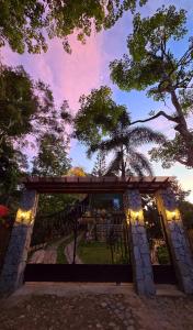 a gate with a view of a garden at dusk at Villa Suíça Guaramiranga in Guaramiranga +29 photos
