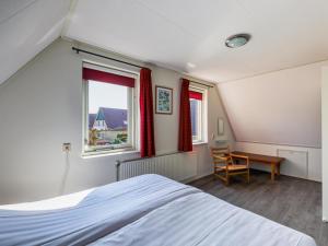 a bedroom with a bed and a desk and a window at Landhuis 42 in Schoonloo