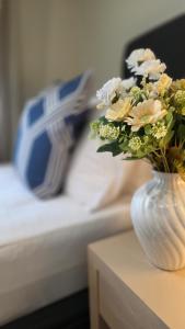 a vase of flowers on a table next to a bed at TOWER JUNCTION MOTOR LODGE- Motel with Airport and Railway Station Transport Service in Christchurch