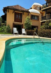 einen Pool mit zwei Stühlen vor einem Haus in der Unterkunft Villa Arqueologica in Playa del Carmen