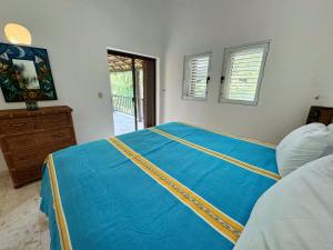 ein Schlafzimmer mit einer blauen Bettdecke auf einem Bett in der Unterkunft Villa Arqueologica in Playa del Carmen + 11 Fotos