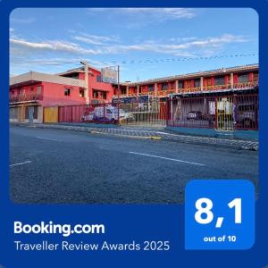 a sign that says travel review awards with a building at Hotel Costa del Sol in Puerto Limón