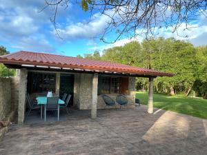 RianjoChalet playa Rianxo的天井上配有桌椅的凉亭