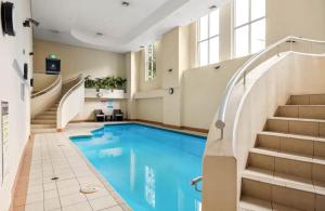 einen Pool mit einer Treppe und einem Pool in der Unterkunft Surry Hills Loft-Style Heritage 1BR - Indoor Pool, Sauna & Gym in Sydney