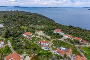 an aerial view of a house on a hill next to the water at Apartments with parking space Savar, Dugi otok - 12762 in Brbinj