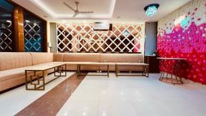 a living room with a couch and a wall of wine glasses at HOTEL O THE VIRAAT in Noida +11 photos
