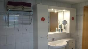 a white bathroom with a sink and a mirror at Crosta Brava in Großdubrau +38 photos