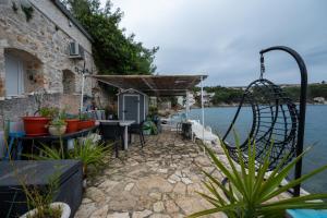 a house on the water with a swing at Apartments by the sea Savar, Dugi otok - 23087 in Veli Rat +6 photos
