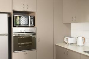 a kitchen with a microwave above a oven at Saltair Retreat in Gold Coast