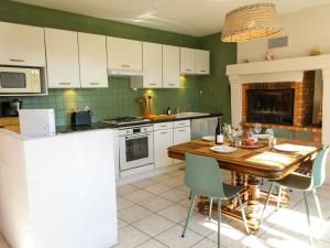 Il comprend une cuisine avec une table en bois et des placards blancs. dans l'établissement Gîte familial entre Angers et Saumur - FR-1-622-104, à Saint-Sulpice