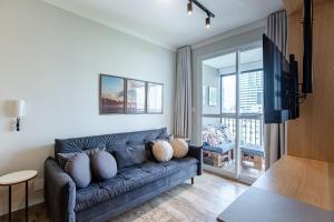 Una sala de estar con un sofá con almohadas. en Studios Sampa - Parque Augusta, en São Paulo