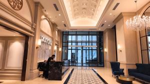a man sitting at a desk in a lobby at Paxtonz Mana-Mana Suites Kuala Lumpur in Petaling Jaya