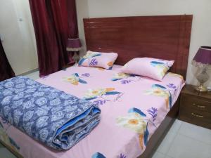 a bedroom with a bed with pink and blue sheets at S I Appartements in Dakar