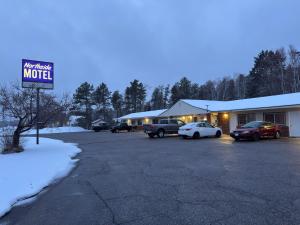 un motel con coches aparcados en un estacionamiento en Northside Motel, en Vermilion Bay