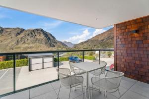 ein Balkon mit Tisch und Stühlen und Bergen in der Unterkunft Residence du Parc by Staysouth in Queenstown