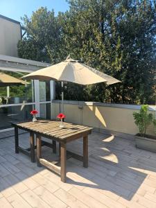 a wooden table with an umbrella on a patio at Luna City in Ravenna +14 photos