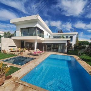 Una casa grande con piscina delante de ella. en Sea Breese Golf & Ocean view Taghazout Bay Amda, en Taghazout