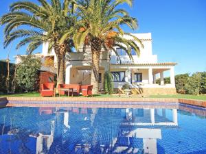 a house with palm trees and a swimming pool at Villa in L'Escala near Platja de Riells Beach in L'Escala