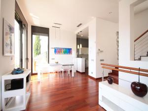 a kitchen and dining room with white walls and wood floors at Luxury villa with amazing sea view in L'Escala