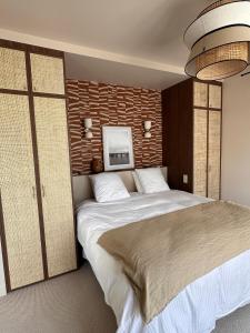a bedroom with a large bed and a wall at Villa Georgia in Bénerville-sur-Mer