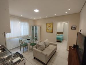 a living room with a couch and a glass table at Meu aconchego com hidromassagem e churrasqueira in Sao Paulo