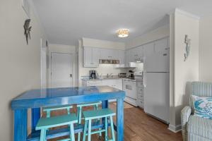 a kitchen with a blue table and two chairs at Summer School condo in Atlantic Beach