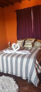 ein Bett mit einer gestreiften Decke und Kissen darauf in der Unterkunft Casa vista al Rio Parana Vuelta de Obligado in San Pedro + 16 Fotos