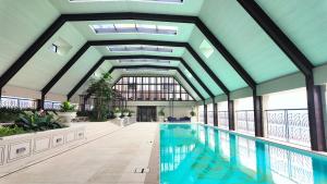 a swimming pool in a building with a ceiling at Paxtonz Leisure Suites Kuala Lumpur in Petaling Jaya