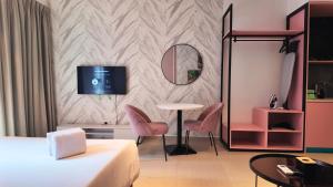 a hotel room with a bed and a table and chairs at Paxtonz Leisure Suites Kuala Lumpur in Petaling Jaya