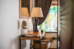 a desk with a lamp and a chair next to a window at Coco Lodge in Gili Trawangan +6 photos