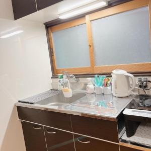 una cucina con un lavello e un piano di lavoro di ペットと泊まれる 日田の宿 Hita Hostel With Pets a Hita Altre 12 foto