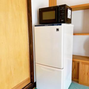 un forno a microonde seduto sopra un frigorifero di ペットと泊まれる 日田の宿 Hita Hostel With Pets a Hita