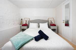 a bedroom with a white bed with a blue blanket on it at Maison Tiffany- Downtown in Montréal
