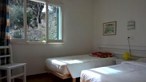 a bedroom with two beds and a window at Apartamentos Encanto Del Mar in Cala Galdana +37 photos