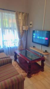 - un salon avec une table basse devant une télévision dans l'établissement Little Haven!, à Rustenburg