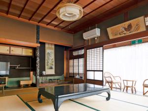 a living room with a table and a tv at Ryouriryokan Asahikan in Shionoha