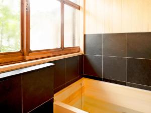 a bathroom with black tiles and a window at Ryouriryokan Asahikan in Shionoha +82 photos