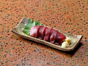 a piece of meat on a plate on a table at Ryouriryokan Asahikan in Shionoha