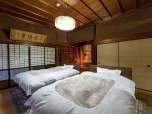 a bedroom with two beds and a chandelier at Ryouriryokan Asahikan in Shionoha