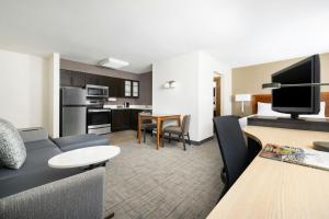 a living room with a couch and a dining room at Residence Inn Des Moines West at Jordan Creek Town Center in West Des Moines