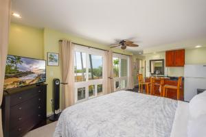 a bedroom with a large bed and a dining room at Kona Wave Rider - Island Sanctuary with Ocean Soul in Kailua-Kona
